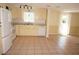 Spacious kitchen with white appliances, plenty of cabinets, tiled floors, and a sliding glass door at 1270 Manor Rd, Englewood, FL 34223