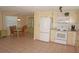 Open kitchen and dining area with a refrigerator, stove, microwave, and a decorative hutch at 1270 Manor Rd, Englewood, FL 34223