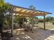 Outdoor patio featuring a wooden pergola with a dining table and lounge chairs at 1270 Manor Rd, Englewood, FL 34223