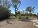 A view of the property with a large yard, mature trees, and native landscape at 1270 Manor Rd, Englewood, FL 34223