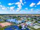 Panoramic aerial shot of a neighborhood with pond, community buildings, and mature trees at 13575 Clara Ln, Port Charlotte, FL 33981