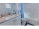Bright bathroom with granite vanity top, white cabinets, and tiled tub and shower at 13575 Clara Ln, Port Charlotte, FL 33981