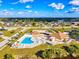Aerial view of community pool, tennis courts and clubhouse in a well kept suburban environment at 13575 Clara Ln, Port Charlotte, FL 33981