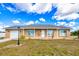 Charming one-story home with a well-manicured lawn and neutral-toned facade, complemented by a gray roof and an attached garage at 13575 Clara Ln, Port Charlotte, FL 33981