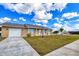 Charming single-story home with landscaped front yard, garage, and sidewalk at 13575 Clara Ln, Port Charlotte, FL 33981