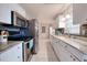 Modern kitchen features stainless steel appliances, granite countertops, white cabinets, and tile flooring at 13575 Clara Ln, Port Charlotte, FL 33981