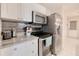 Modern kitchen features stainless steel appliances, granite countertops, white cabinets, and tile flooring at 13575 Clara Ln, Port Charlotte, FL 33981