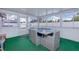 Enclosed patio with natural lighting, dining table, and durable green carpeting at 13575 Clara Ln, Port Charlotte, FL 33981
