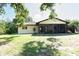 Spacious backyard featuring a screened lanai, lush lawn, and mature trees, perfect for outdoor living at 1497 Fireside St, Port Charlotte, FL 33952