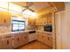 Cozy kitchen featuring wood cabinets, black appliances, and a double basin sink at 1497 Fireside St, Port Charlotte, FL 33952