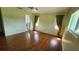 Bedroom featuring hardwood floors, a ceiling fan, windows, and closet with view into bathroom at 18054 Ackerman Ave, Port Charlotte, FL 33948