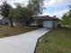 Charming brick home with an attached garage and a long driveway leading to the residence at 18054 Ackerman Ave, Port Charlotte, FL 33948