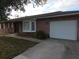 Brick home featuring a bay window and a single car garage with a concrete driveway at 18054 Ackerman Ave, Port Charlotte, FL 33948