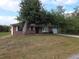 Quaint brick home with mature trees, a bay window, and an attached single-car garage at 18054 Ackerman Ave, Port Charlotte, FL 33948
