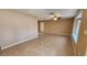 Large open living room with tile flooring, ceiling fan and natural light from window at 18054 Ackerman Ave, Port Charlotte, FL 33948