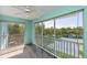 Serene screened balcony with ceiling fan offering views of tennis courts and tropical foliage at 19385 Water Oak Dr # 302, Port Charlotte, FL 33948
