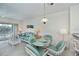 Bright dining area with glass table, wicker chairs, and view of the living room at 19385 Water Oak Dr # 302, Port Charlotte, FL 33948