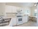 Well-lit kitchen with white cabinets, modern appliances, and a cozy dining area with tile floors at 19385 Water Oak Dr # 302, Port Charlotte, FL 33948
