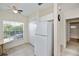 Efficient kitchen layout with white refrigerator, ample storage, and a bright window with tile floors at 19385 Water Oak Dr # 302, Port Charlotte, FL 33948