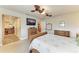 Bright bedroom featuring wicker furniture, an ensuite bathroom, and views to the outdoors at 200 Capri Isles Ct, Punta Gorda, FL 33950