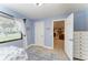 Light-filled bedroom featuring a nautical theme, light-blue walls, and wood-look floors at 200 Capri Isles Ct, Punta Gorda, FL 33950