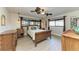 Charming bedroom featuring a wooden bed frame, ceiling fan, and windows with stylish curtains at 200 Capri Isles Ct, Punta Gorda, FL 33950