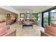 Light-filled Florida room featuring tile floors, comfortable seating, and backyard views at 200 Capri Isles Ct, Punta Gorda, FL 33950