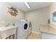 A convenient laundry room including a utility sink, washer, dryer, and granite countertops at 200 Capri Isles Ct, Punta Gorda, FL 33950