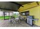 Outdoor patio area with a grill, seating, and lush landscaping, ideal for enjoying the outdoors at 200 Capri Isles Ct, Punta Gorda, FL 33950