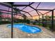 Screened in pool with a view of the canal and a colorful sunset at 200 Capri Isles Ct, Punta Gorda, FL 33950