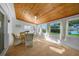 Inviting sunroom with wood ceilings, tile floors, large windows, and comfortable wicker seating at 21249 Higgs Dr, Port Charlotte, FL 33952