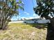 A spacious backyard featuring a well-kept lawn, a patio, a white fence, and mature trees at 2600 Mohegan Rd, Venice, FL 34293