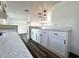 Bright kitchen featuring white cabinets, stylish lighting and luxury gray and white countertops at 2600 Mohegan Rd, Venice, FL 34293