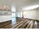 Bright living area with wood floors, a kitchen view, and sliding glass doors leading to the yard at 2600 Mohegan Rd, Venice, FL 34293