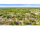 Expansive aerial view of a home nestled in a lush, tree-filled neighborhood under a bright blue sky at 2677 Martin St, Sarasota, FL 34237