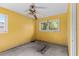 Empty bedroom showcasing bright yellow walls and ceiling fan, ready to be transformed at 2677 Martin St, Sarasota, FL 34237