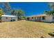 Expansive backyard featuring a detached garage, the side of the home, and a lush lawn under a clear blue sky at 2690 Auburn Blvd, Port Charlotte, FL 33948