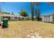 Spacious backyard featuring a lush lawn, a detached garage, and the rear of the home under a clear blue sky at 2690 Auburn Blvd, Port Charlotte, FL 33948