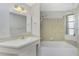 Bathroom boasts a tub with a showerhead, along with neutral decor and mirror at 2690 Auburn Blvd, Port Charlotte, FL 33948