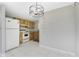 Kitchen and dining area featuring updated lighting fixture and kitchen cabinets at 2690 Auburn Blvd, Port Charlotte, FL 33948
