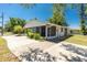 Charming single-story home with a screened-in porch, driveway, and manicured landscaping under a clear blue sky at 2690 Auburn Blvd, Port Charlotte, FL 33948