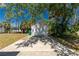 Detached one car garage with a concrete driveway amid lush greenery under a clear blue sky at 2690 Auburn Blvd, Port Charlotte, FL 33948