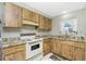 A kitchen featuring wooden cabinetry, granite countertops, and a white electric stove and oven at 2690 Auburn Blvd, Port Charlotte, FL 33948