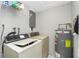 Utility room featuring a washer, dryer, water heater, and a storage shelf at 2690 Auburn Blvd, Port Charlotte, FL 33948