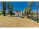 Backyard shed by a waterway amid lush trees under a clear blue sky at 2690 Auburn Blvd, Port Charlotte, FL 33948