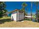 Backyard shed by a waterway amid lush trees under a clear blue sky at 2690 Auburn Blvd, Port Charlotte, FL 33948