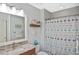 Cozy bathroom features a nautical-themed shower curtain, decorative shelving, and a granite-topped vanity at 28059 Arrowhead Cir, Punta Gorda, FL 33982