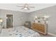 Well-lit bedroom features a ceiling fan, light wood floors, and neutral-colored walls at 28059 Arrowhead Cir, Punta Gorda, FL 33982