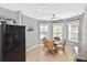 Charming breakfast nook with bay windows, a ceiling fan, and adjacent black refrigerator at 28059 Arrowhead Cir, Punta Gorda, FL 33982