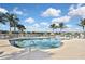 Inviting community pool area with ample lounge chairs and swaying palms, a perfect spot for relaxation at 28059 Arrowhead Cir, Punta Gorda, FL 33982